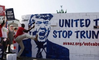 INCREDIBIL! Activiştii anti-Trump au dărâmat un „Zid al Berlinului“ cu figura lui Trump în faţa Porţii Brandenburg